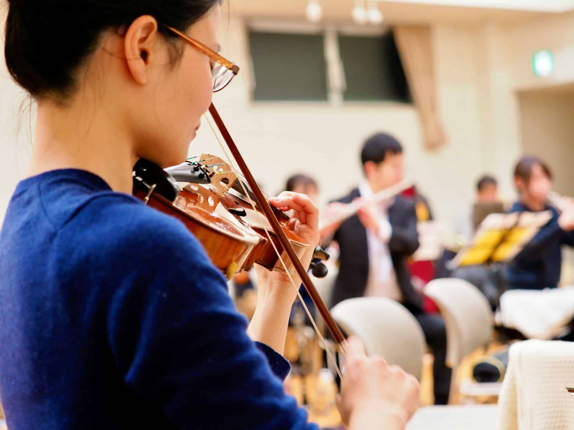 Girl playing violin as part of an orchestra